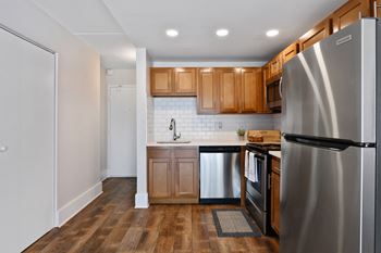 Galley kitchen with stainless steel appliances and wood cabinets